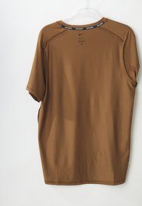 Camisa atlética castanha com um tecido texturizado e mangas curtas. Apresenta um decote redondo e um acabamento preto com a marca ao longo do colarinho.