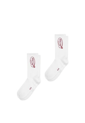 Ein Paar weiße Crew-Socken mit rotem kursive geschriebenem "Lacatus"-Logo auf der Wade und der Größe 43-46, die in der Nähe der Zehen aufgedruckt ist.