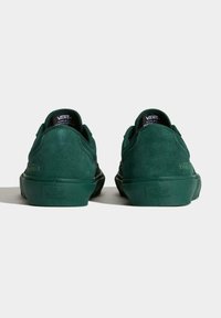 Las zapatillas de skate de ante verde presentan un diseño de corte bajo, un collar acolchado y una suela de goma texturizada con acentos del logo de Vans en el talón y la lengüeta.