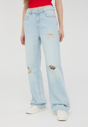 Jeans azzurri chiari a vita alta, con una vestibilità ampia, caratterizzati da molteplici strappi distressed, completati da un classico stile a cinque tasche e bottone metallico.