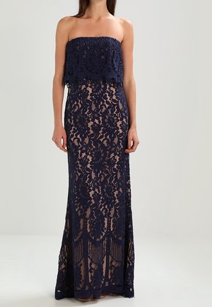 Vestido largo azul marino sin tirantes de encaje con patrones florales intrincados, diseño en capas y silueta ajustada que se extiende hasta el suelo.