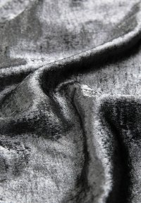 Tarfă neagră texturată cu un aspect moale și catifelat; prezintă o strălucire subtilă și ondulații, evidențiind căderea sa fluidă și finisajul neted.