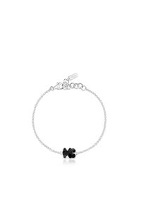 Pulsera de cadena de plata que presenta una piedra negra central en forma de trébol, con un diseño de eslabones delicados y una pequeña etiqueta grabada con "TOUS."