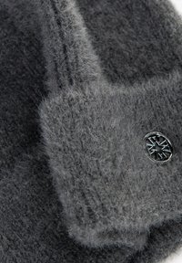 Grijze wollen muts met een zachte, pluizige textuur. Heeft een gebreid ontwerp en een metalen logo-accent. Dikke, warme stof voor comfort.