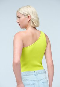 Jednoramenný, žebrovaný body v jasné limetkové green, s elegantním designem a přiléhavým střihem a texturovaným povrchem.
