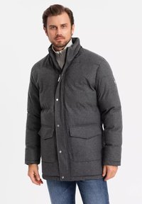 Giubbotto imbottito grigio con colletto alto, due tasche frontali e chiusura con zip, realizzato in tessuto morbido e testurizzato. Adatto per il clima freddo.