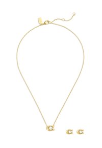 Ensemble de bijoux dorés comprenant un collier délicat avec une chaîne et un pendentif rond contenant une perle, ainsi que des boucles d'oreilles à puce en perle assorties.