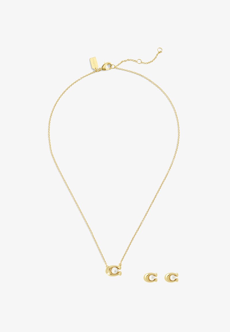 Ensemble de bijoux dorés comprenant un collier délicat avec une chaîne et un pendentif rond contenant une perle, ainsi que des boucles d'oreilles à puce en perle assorties.