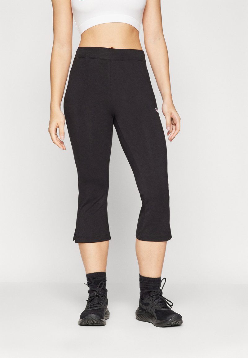 Leggings capri negros con una textura suave, que cuentan con una cinturilla de altura media y aberturas laterales en el dobladillo para facilitar el movimiento.