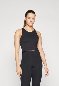 Black, cropped athletic tank top with a round neckline and wide straps, paired with high-waisted, fitted black leggings. Smooth texture.
