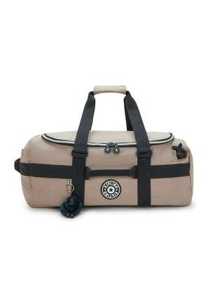 Borsa a sacco Kipling beige con cinghie nere, cerniera superiore, logo rotondo e portachiavi con piccolo peluche a forma di scimmia attaccato.