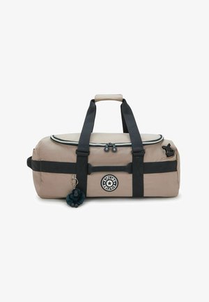 Beige Kipling duffel bag with black straps, top zipper, round logo, and attached small plush monkey keychain.