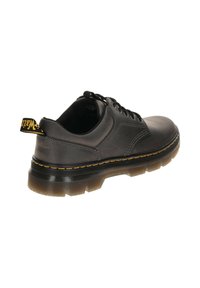 Schwarze Leder Schnürschuhe mit einer glatten Oberfläche, einer dicken durchsichtigen Sohle und einem gelben Logo-Akzent am hinteren Ziehband.