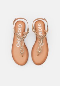 Sandalias planas en tono marrón con un diseño de tira trenzada dorada, con una plantilla acolchada y punta abierta. Nombre de la marca "GIOSEPPO" visible en las plantillas.