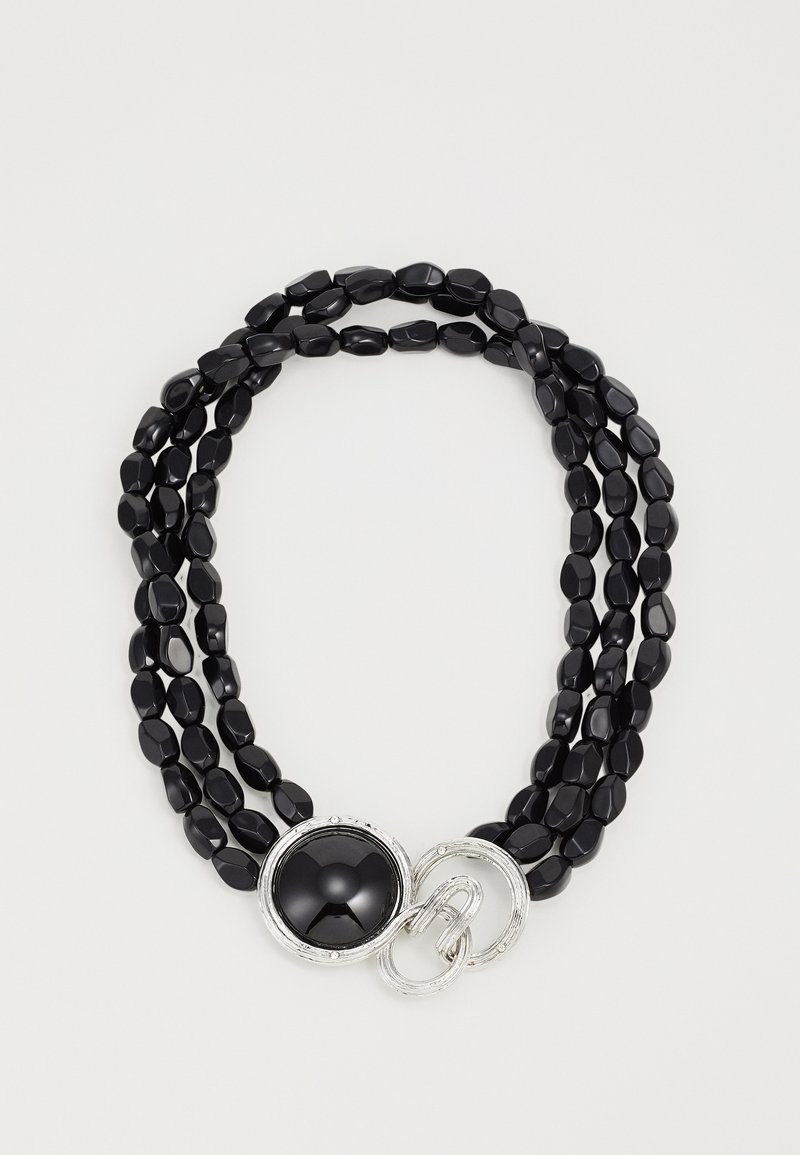 Zwarte kralenketting met drie strengen. Ovaalvormige kralen met een gladde textuur; heeft een ronde zwarte centrale schakel en zilveren hardware accent.