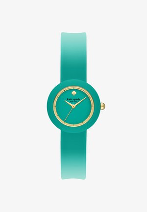 Tealfärgad silikonarmbandsur med rund urtavla, guldiga detaljer och en spade-logotyp. Slät yta och ombré-armband som övergår från teal till en ljusare nyans.