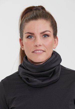 Sort halsedisse med tekstureret design, lavet af strækbart stof. Båret med en tætsiddende sort top, som viser et tæt på billede.
