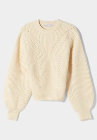 Kermanvärinen neuleoleva pyöreällä kaula-aukolla, ribatusta tekstuurista ja etuosassa johdinleikkauksista. Ominaisuudet pitkissä, hieman puffatatuissa hihoissa.