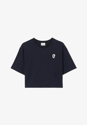 T-shirt court bleu marine en coton, avec des manches courtes et un petit logo clair sur la poitrine. Design simple et texture lisse.