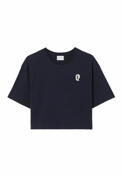 T-shirt court bleu marine en coton, avec des manches courtes et un petit logo clair sur la poitrine. Design simple et texture lisse.