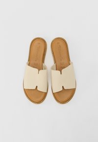 Beige leather slide sandals with a wide upper band, open toe, and stitched trim. Soft brown insole, minimalist design, size 37.