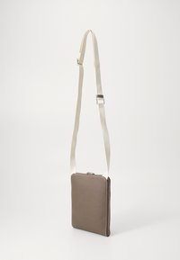 Tan crossbody veske med glidelås, glatt tekstur, rektangulær form og kremfarget justerbar stropp. Har sydd detaljer.