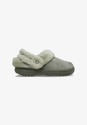 Sabot gris à enfiler avec doublure en fourrure douce et sangle en fourrure réglable sur une semelle en caoutchouc texturée, vu de profil.