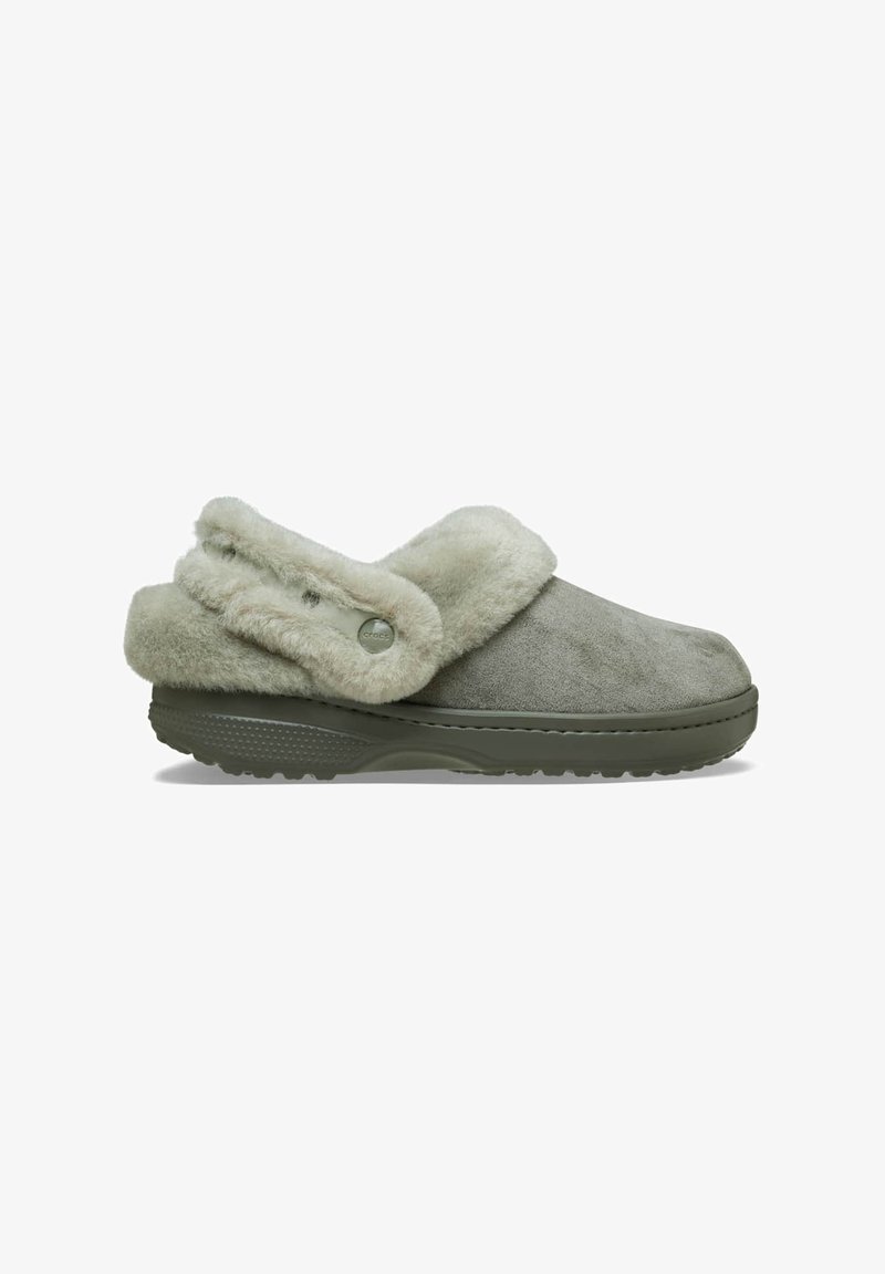 Sabot gris à enfiler avec doublure en fourrure douce et sangle en fourrure réglable sur une semelle en caoutchouc texturée, vu de profil.