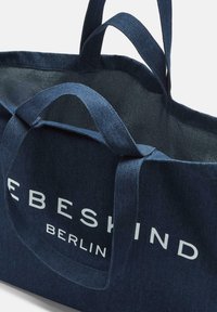 Navy Denim Tote Bag mit zwei stabilen Griffen, auf einer Seite mit weißem Drucktext "EBESHIND" und "BERLIN", strukturierter Stoffoberfläche.