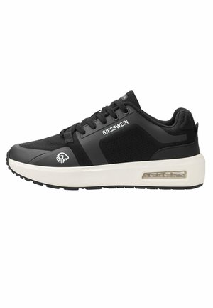 Czarny niski sneaker z białą podeszwą, przezroczystą poduszką powietrzną, czarnymi sznurowadłami i oznaczeniem Giesswein po boku i na języku.