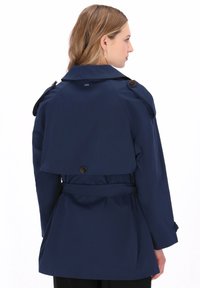 Tengerészkék ballonkabát két soros gombokkal, állítható övvel és hátsó redőzéssel. Sima anyag, testre szabott szabás.