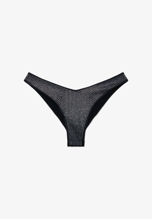 Mutandine nere in stile perizoma con un design a taglio alto, completamente ricoperte da piccoli borchie argento uniformemente distanziate.