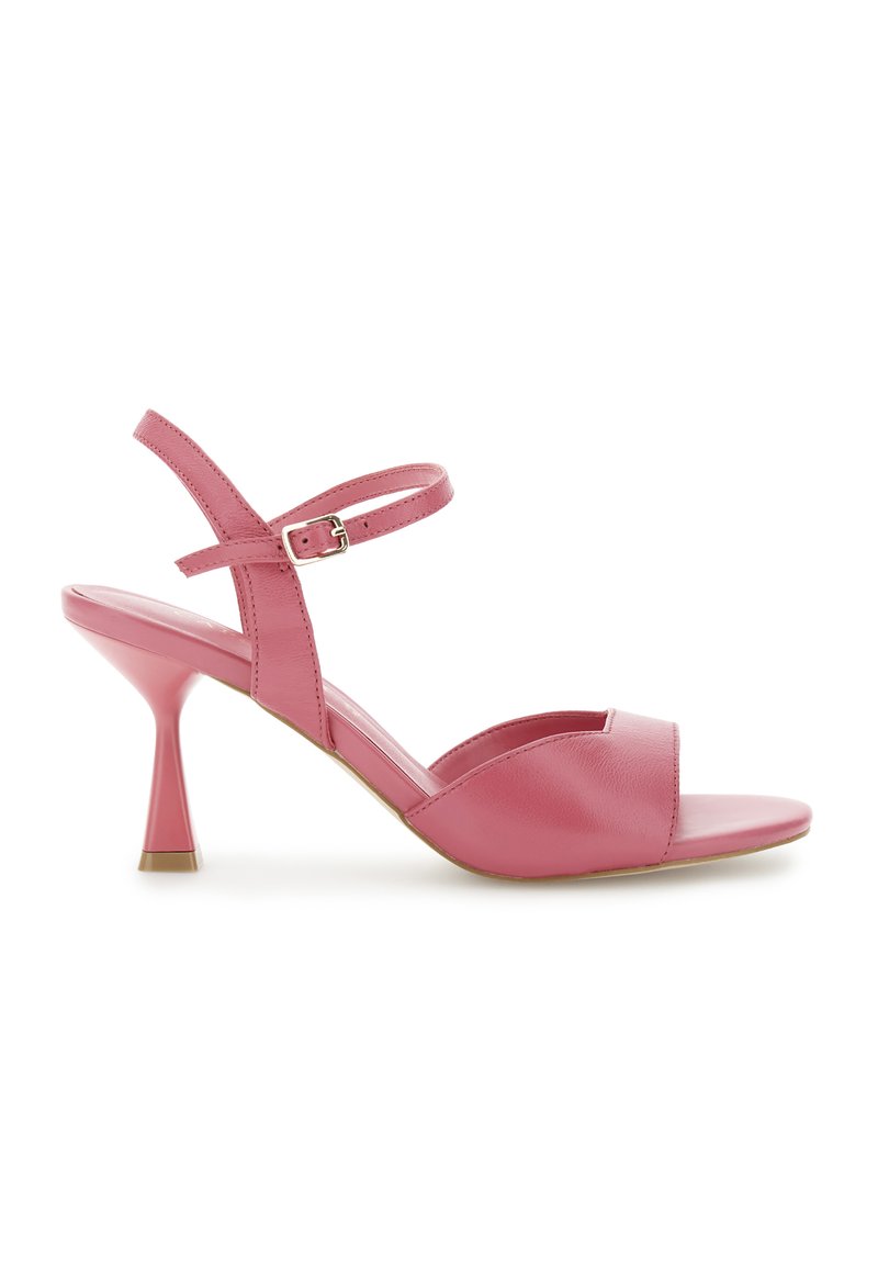 Roze leren hoge hakken sandalen met een kruisband met een gesp, open teen en een uniek flared hakontwerp.
