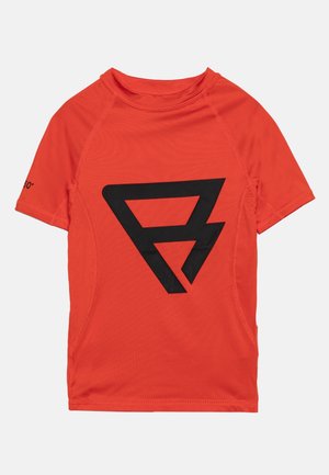 Jaskrawy pomarańczowy rash guard z krótkim rękawem, dużym czarnym geometrycznym logo na przodzie oraz metką z ochroną UV 50+ na rękawie.