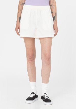 Crème-kleurige katoenen shorts met een ontspannen pasvorm, voorzien van een elastische tailleband en zijzakken. Draag het met zwarte sneakers en witte sokken.