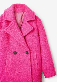 Manteau rose à double boutonnage en tissu texturé, avec deux boutons noirs, un col cranté et des poches avant. Intérieur doublé.