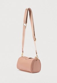 Τσάντα χειρός από απαλό ροζ δέρμα με στρογγυλεμένες άκρες, επάνω κλείσιμο με φερμουάρ και ρυθμιζόμενο λουράκι με λεπτομέρειες σε χρυσό τόνο.