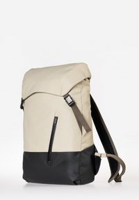 Beige- und schwarze Tasche mit einem Roll-Top-Design, ausgestattet mit einer vorderen Reißverschlusstasche, verstellbaren Schulterriemen und glattem, strapazierfähigem Material.