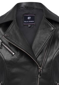Zwarte leren motorjack met zilveren ritsen, knopen met drukknop en een label met "FELIX HARDY." Glad oppervlak met een aansluitend ontwerp.