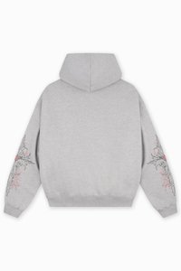Szara bluza z kapturem i długimi rękawami. Posiada graficzny wzór w czerni i czerwieni na lewym rękawie. Miękka tekstura materiału oraz luźny krój.