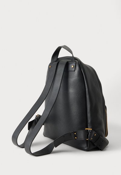 Sac à dos en cuir noir avec des bretelles réglables et une poignée supérieure, vu de dos sur un fond clair.
