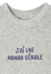 Helles graues Babyhemd mit dunkelblauem Text auf Französisch, der "J'ai une maman géniale" liest, und einem kleinen Stern über dem Schriftzug.