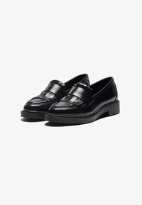 Zwarte leren loafers met een gestructureerde band met franjes, een ronde neus en een chunky rubberen zool voor extra hoogte.