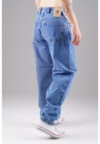 Helle blaue Jeans aus Denim mit einer lockeren Passform, die über fünf Taschen, orangefarbene Nähte und ein geprägtes Lederlabel am Bund verfügt.