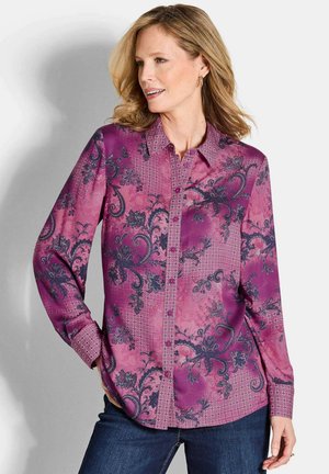 Paarse blouse met een bloemen- en geometrisch patroon, lange mouwen, knoopsluiting aan de voorkant en een gestructureerde kraag. Draag het met donkere jeans.