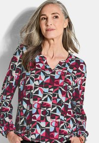 Langsleeve blouse met een geometrisch patroon in rood, zwart en blauw, met een V-hals en gathered manchetten voor een relaxte pasvorm.