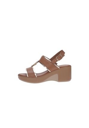 Sandale compensée marron avec deux brides avant, accents métalliques et boucle de cheville réglable sur une semelle beige.