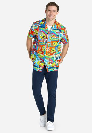 Värvikas lühikeste varrukatega särk, millel on SpongeBob SquarePants graafika punases, sinises ja kollases, koos tumesiniste pükstega ja valgete tossudega.