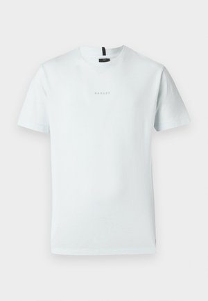 Lys blå bomull t-skjorte med korte ermer, rund hals, og en liten logo brodert i midten. Enkel, udekorerte design.