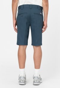 Pantaloni corti blu navy realizzati in tessuto intrecciato, caratterizzati da un taglio dritto, due tasche posteriori con chiusura a bottone e passanti per cintura.